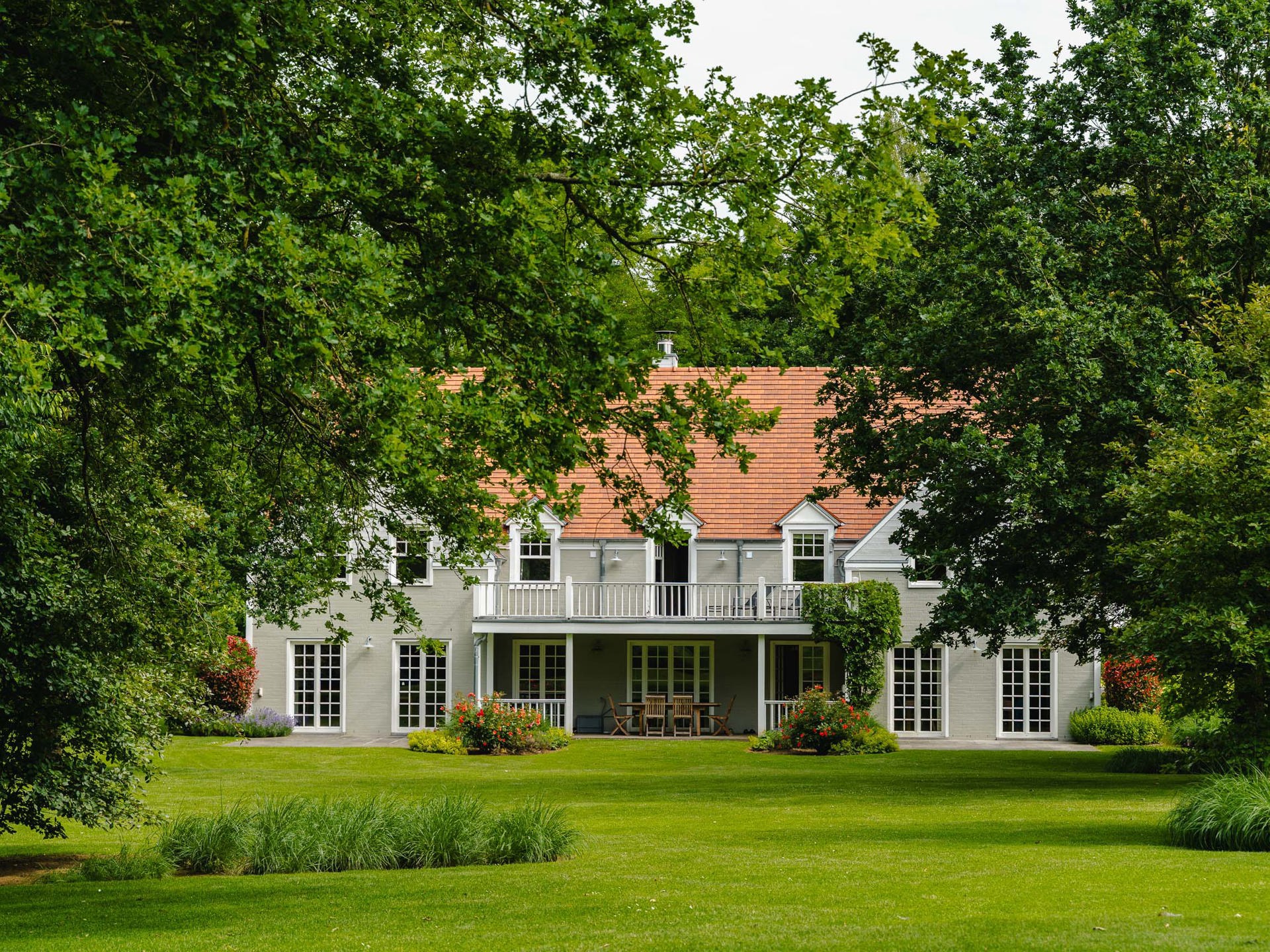 Façade arrière — terrasse couverte et jardin arboré